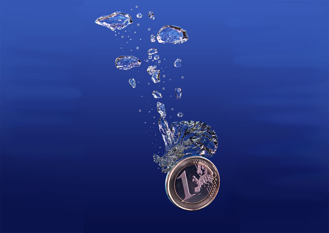 One euro coin falling into water.