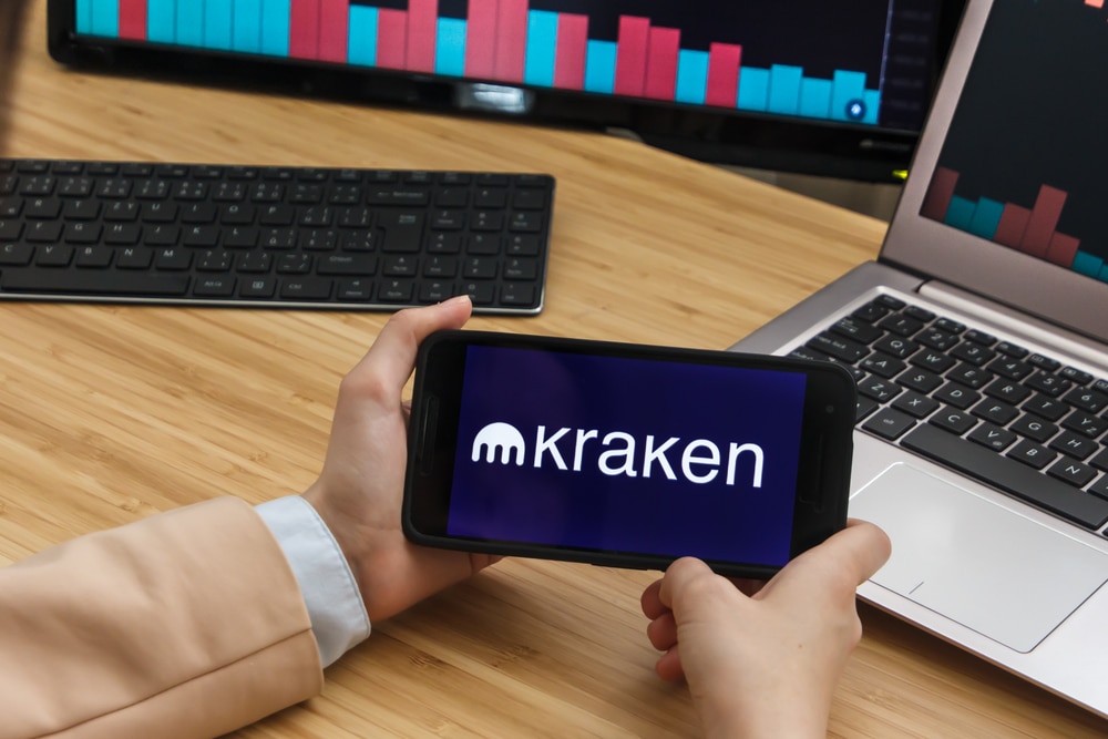 Female Trader Hands Holding the Smartphone Using Application of Kraken Cryptocurrency Exchange Market. Cryptocurrency Background Concept, San Francisco, California, USA.