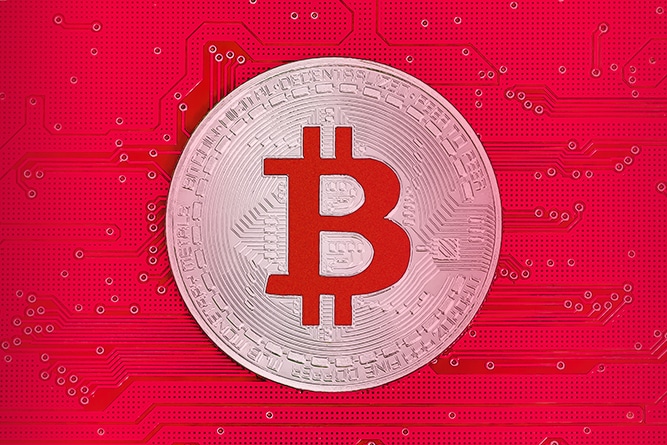 Bitcoin on red circuit board. Bitcoin cryptocurrency on computer electronic circuit board.