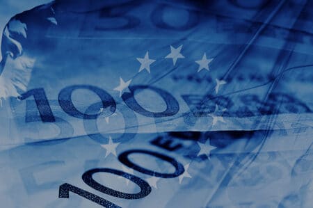 blue background with euro bills and european union flag symbolizing euro zone