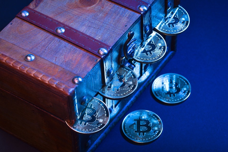 Wooden treasure chest with valuables, bitcoins, pennies or dollars isolated over dark background