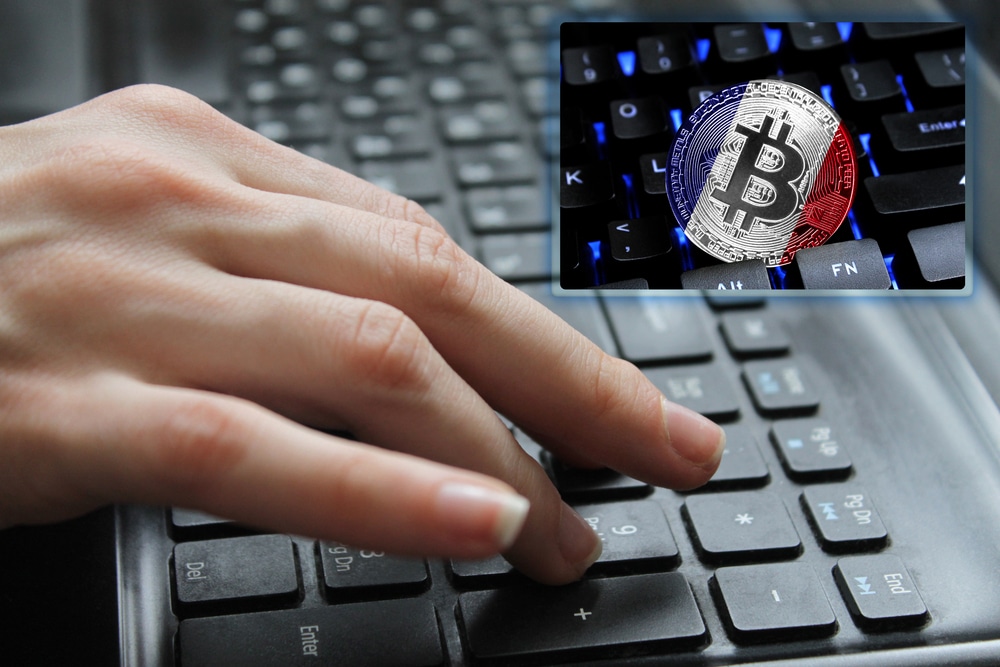 Hand of the girl on the keyboard close up with the concept of digital technology on the purchase and sale of crypto currency bitcoin with a flag of France