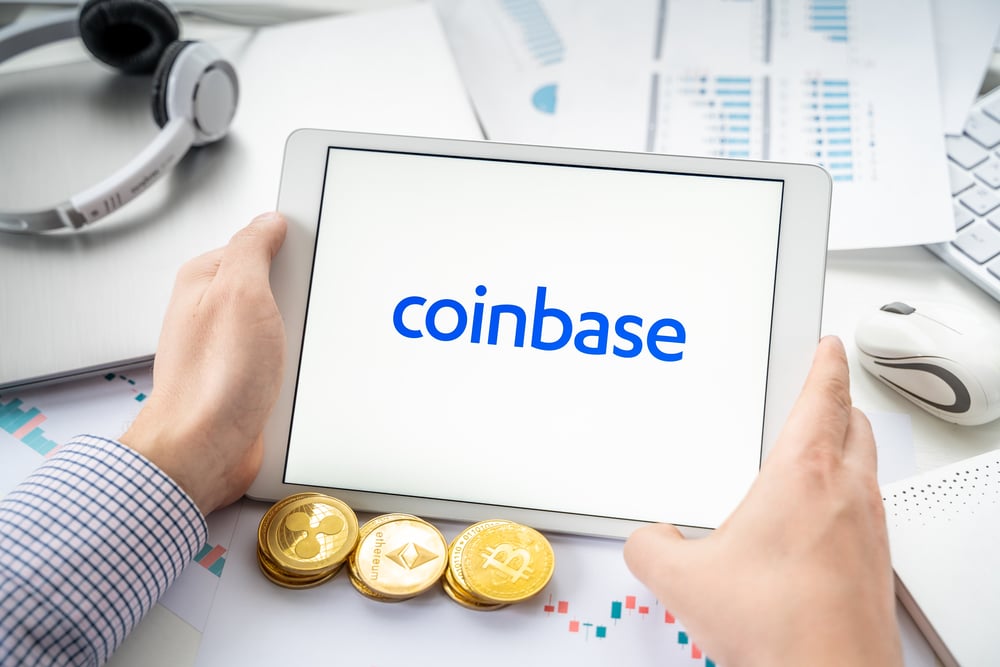 Businessman with tablet.Logo of cryptocurrency stock exchange Coinbase.Trading blockchain platform to buy,sell digital crypto coins,tokens Bitcoin,Ethereum.
