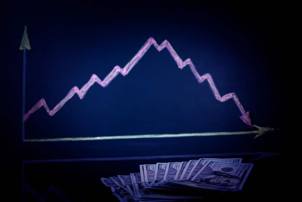 Money lies against the background of a stock drop chart .. The concept of profit decline, limited budget, loss-making business, capital outflow, report, and financial crisis, low income and salary. Drop it, drop it. recession