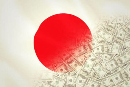Pile of dollars against digitally generated japan national flag