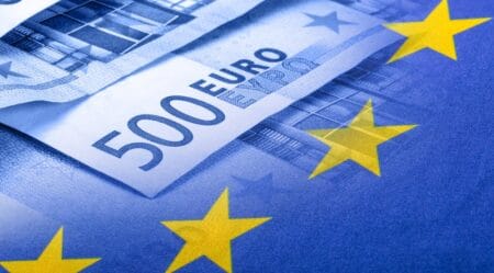 Colorful waving european union flag on a euro money background.