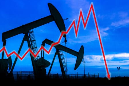 Explicit Illustration depicting the historic fall of the price of crude oil with downdown arrow an oil well in silhouette in the background