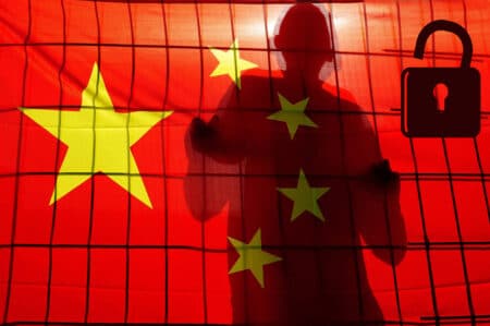Silhouette of man behind fence and China flag
