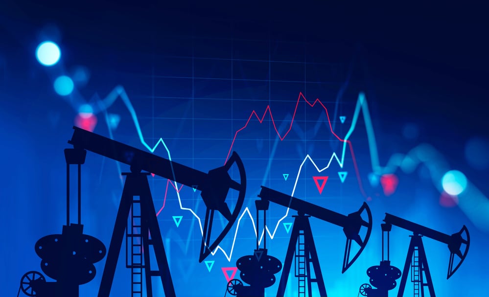 Three oil pumps over blue background with double exposure of falling blurry digital charts. Concept of oil market crisis. 3d rendering toned image