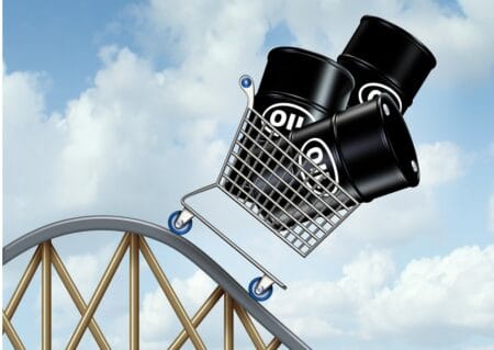 Falling oil prices and plunging fuel costs as a group of oil barrels or steel drum containers in a shopping cart going down on a roller coaster as a business concept of low energy pricing and the unstable nature of commodities.