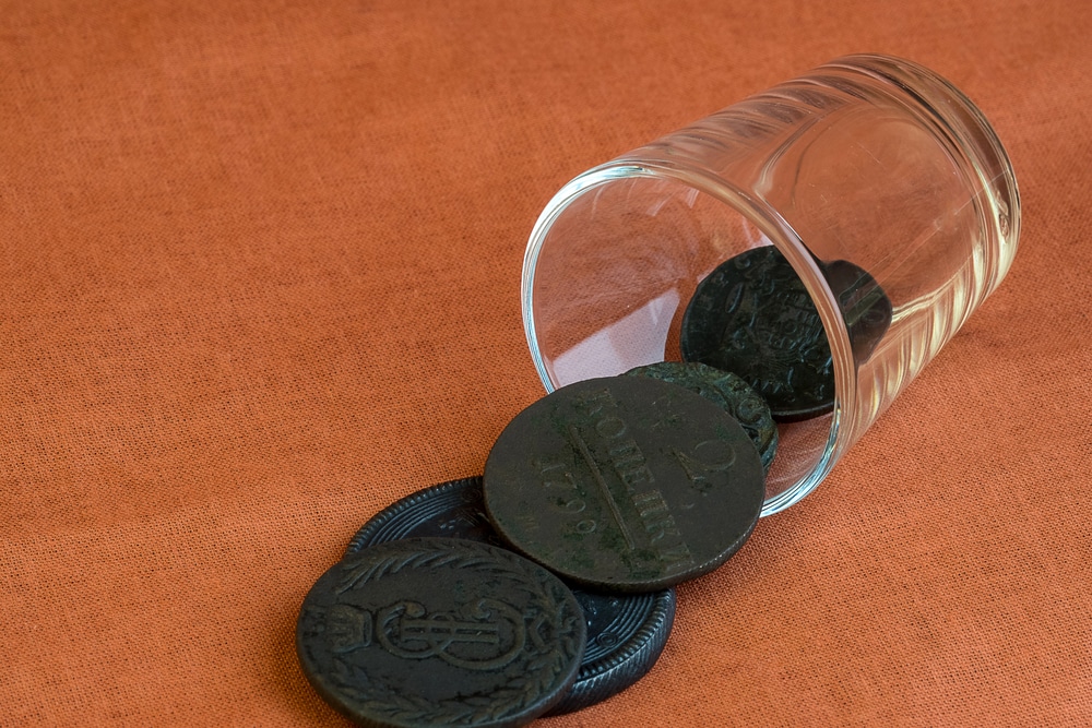 Coins from a glass glass fell on a cloth of orange