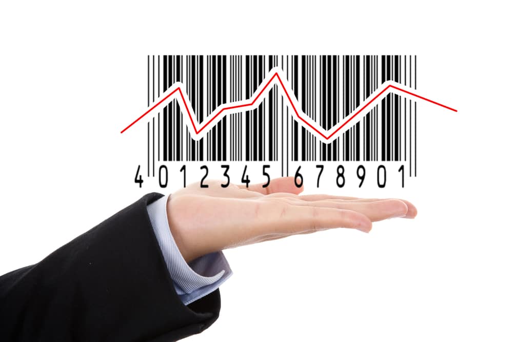businesswoman hand holding barcode illustrating the stock market isolated on white background