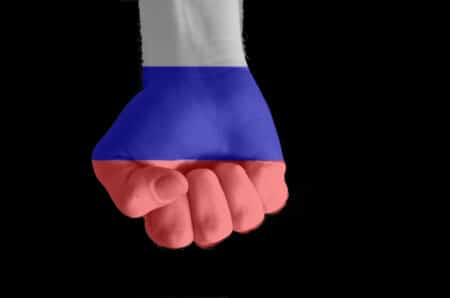 Low key picture of a fist painted in colors of russia flag