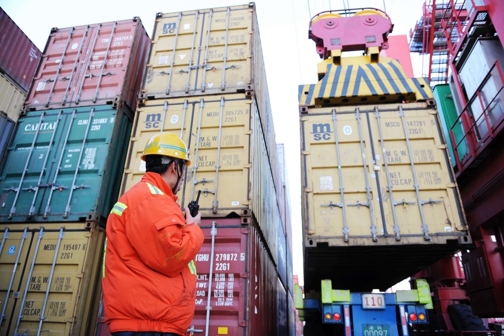 Chinese worker watches a container being lifted at the Port of Qingdao in Qingdao city, east Chinas Shandong province, 30 October 2012.