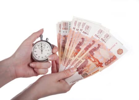 stopwatch and money in the woman's hand on a white