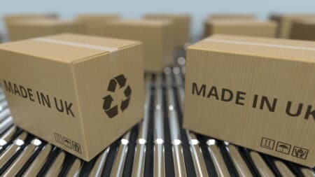 Cartons with MADE IN UK text on roller conveyor. British goods related