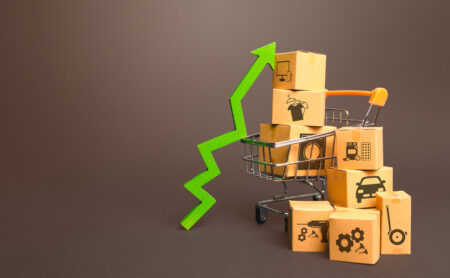 Shopping cart with boxes and green up arrow. Growth trade production, increased sales rate. Improving consumer sentiment. High demand for goods, retail merchandise. Excitement agiotage, rising prices.