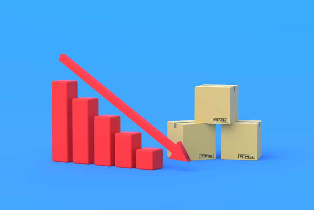 Cardboard boxes near red graphic with down arrow. Reduced costs. Decline investment in the freight market. Falling profitability of transport companies. Import, export statistics. 3d render