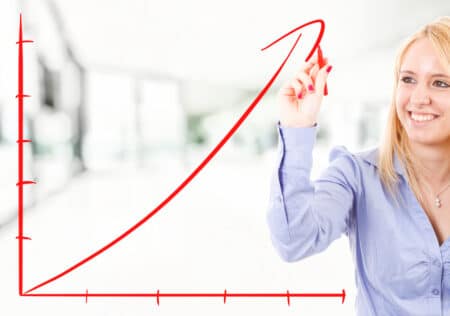 Businesswoman drawing a rising arrow, representing business growth.