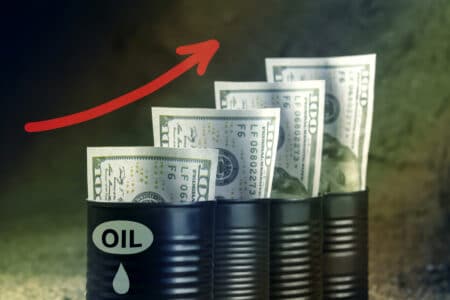 Several barrels of oil with dollars and a red arrow up - concept of higher oil prices.